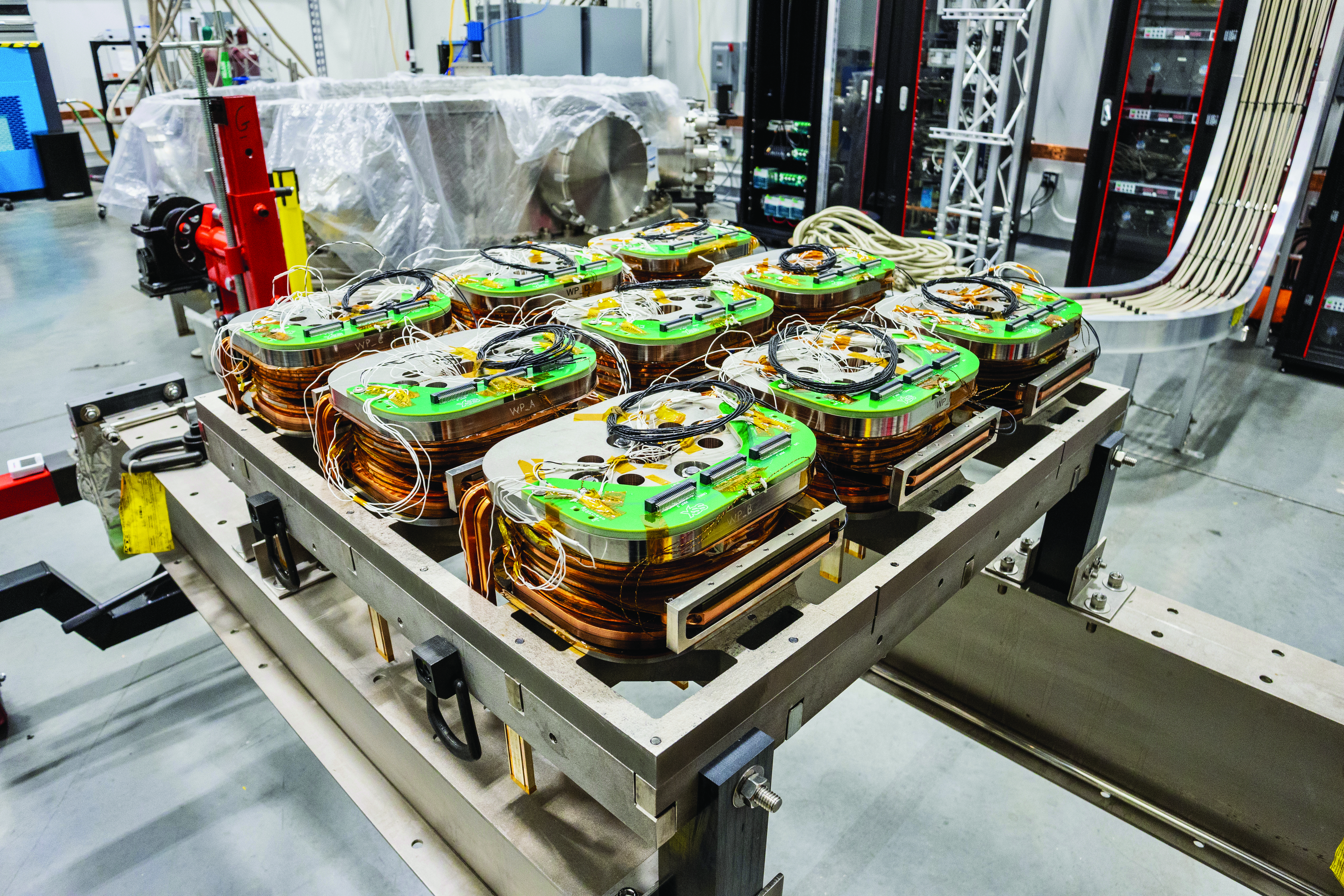 Nine spools of planar coils that a company has tested for its stellarator fusion reactor concept.