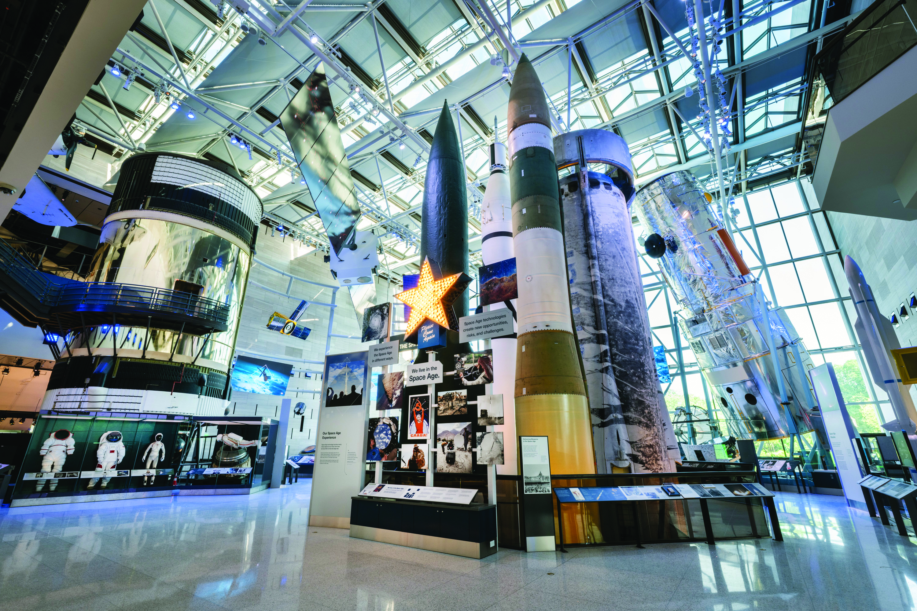 A view of a hall at the Smithsonian’s National Air & Space Museum. Models of rockets are in the foreground, and a model of a large telescope covered in foil is at the back right.
