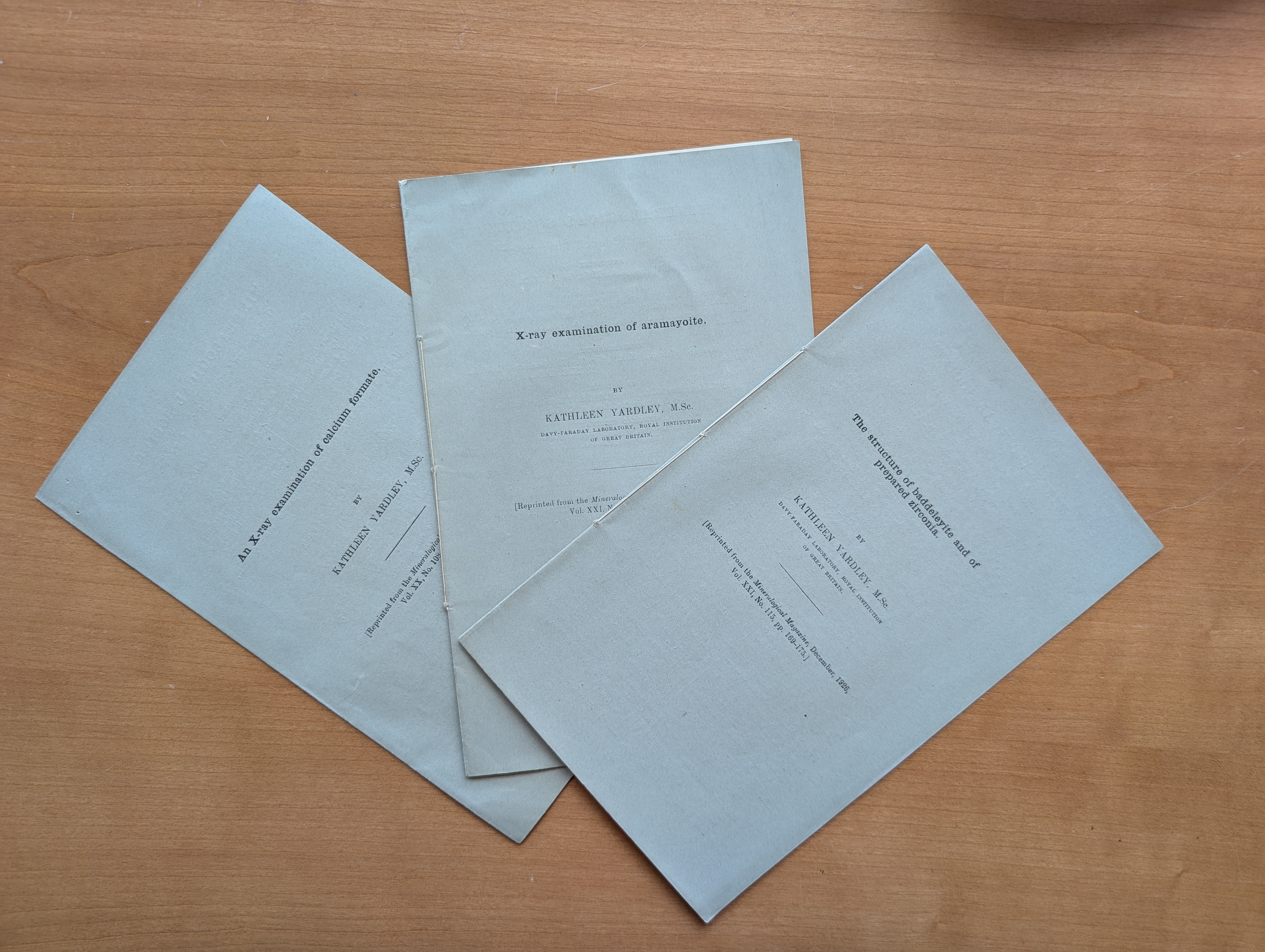 Three paper wrapped items on a desk.