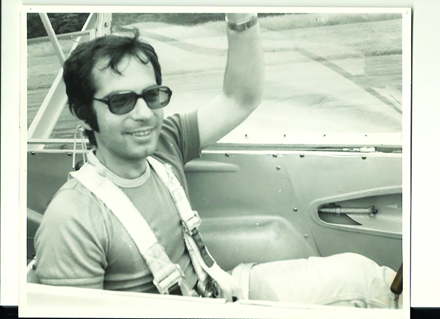 A black-and-white photo of a man in a glider.