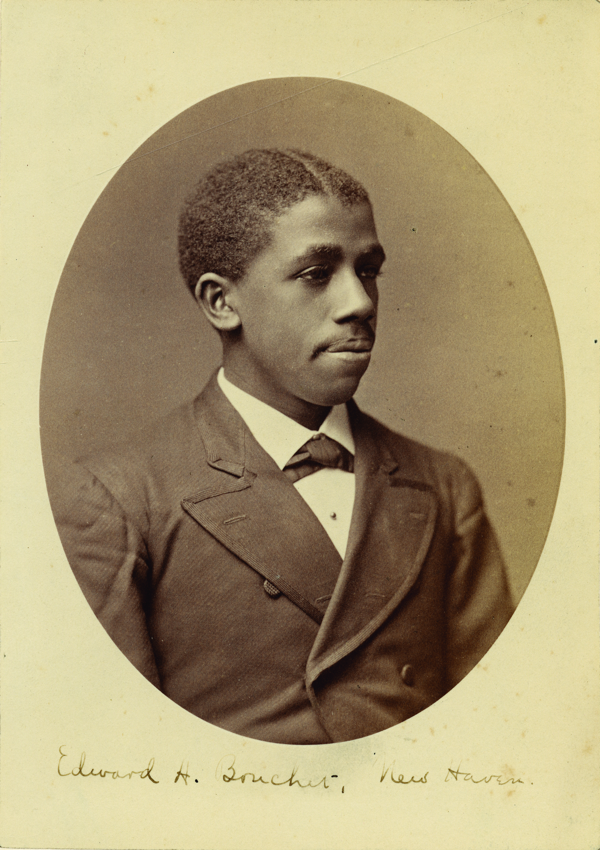 A vintage photo of a young man wearing a suit and tie.