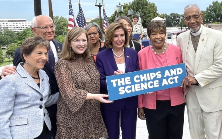 Lawmakers gather around a sign reading "THE CHIPS AND SCIENCE ACT"
