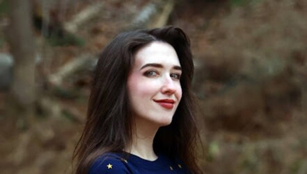 woman standing outdoors, wearing shirt with stars