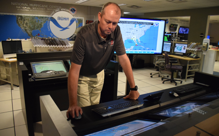 Ken Graham standing over a hurricane monitoring screen