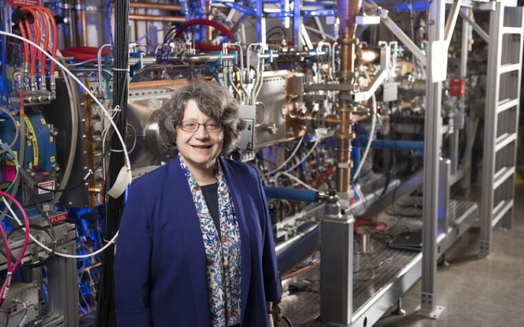 Lia Merminga standing in a physics lab.