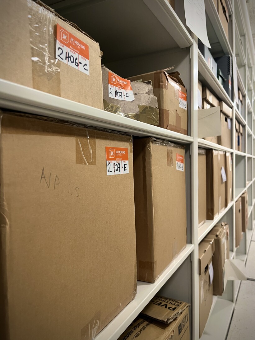 Angled view of cardboard boxes stacked on shelves in the archives