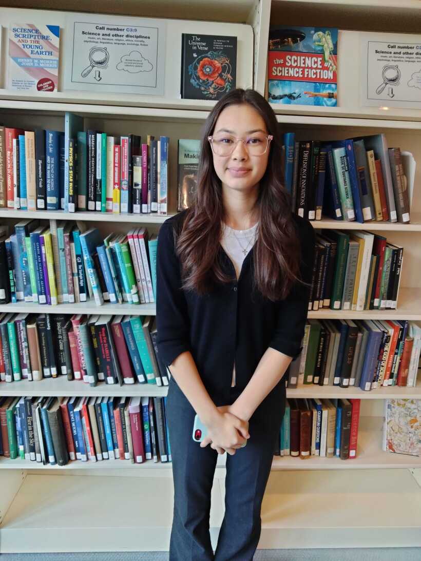 Girl standing in front of a bookshelf